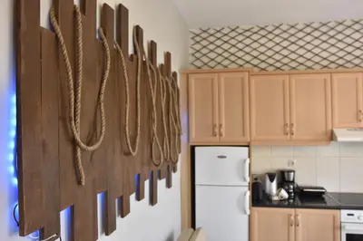 a kitchen with wooden cabinets and ropes hanging on the wall at Casa de Campo 2 in Almirida