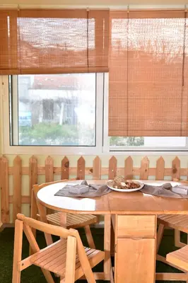 a dining room with a table and two windows at Casa de Campo 2 in Almirida