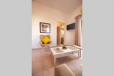 a living room with a table and a yellow pillow at jenny's flat near the sea in Galatás