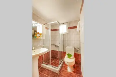 a bathroom with a toilet and a sink and a shower at jenny's flat near the sea in Galatás