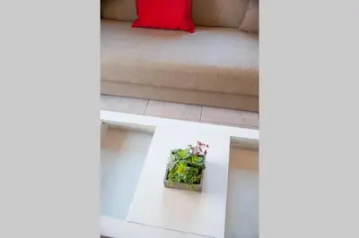 a living room with a couch with a red pillow at jenny's flat near the sea in Galatás