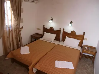 two beds in a room with two white towels at Vafes Traditional Stone Houses in Vafés
