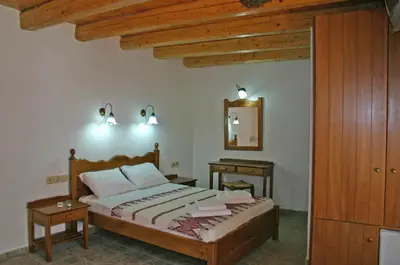 a bedroom with a bed with two tables and a mirror at Vafes Traditional Stone Houses in Vafés