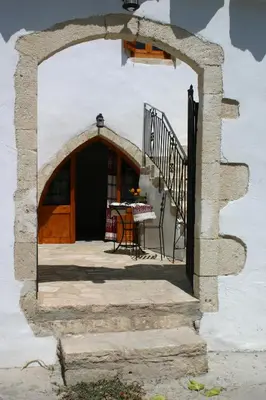 an archway leading to a patio with a table at Vafes Traditional Stone Houses in Vafés