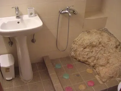 a bathroom with a sink and a large rock at Patriko Traditional Stone Houses in Vafés