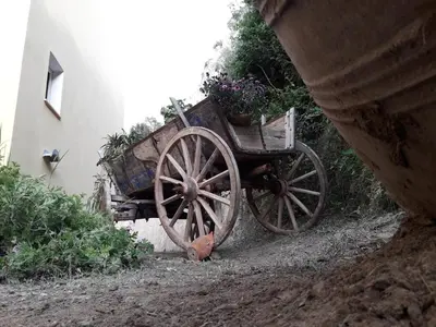 a wooden wagon with flowers in it next to a building at Kalyves Bay in Kalyves