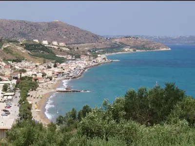 a view of a beach with a town and the ocean at Kalyves Bay in Kalyves