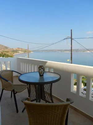 a table on a balcony with a view of the water at Kalyves Bay in Kalyves