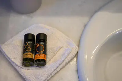 two bottles of alcohol sitting on a towel next to a toilet at Xatheri Villas in Vamos