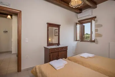 a bedroom with two beds and a mirror at Xatheri Villas in Vamos