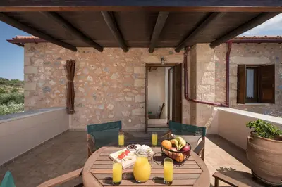a wooden table with a bowl of fruit on a patio at Xatheri Villas in Vamos