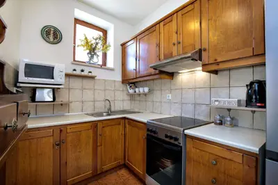 a kitchen with wooden cabinets and a sink and a microwave at Villa Zoi Tzitzifes in Tzitzifés