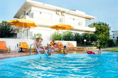 a group of people in a swimming pool at Elena Rooms & Apartments in Gerani Chanion