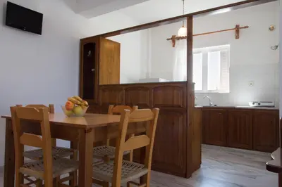 a kitchen with a wooden table with a bowl of fruit on it at Elena Rooms & Apartments in Gerani Chanion