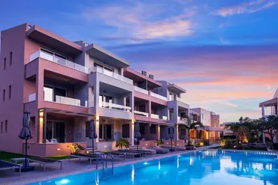 a hotel with a swimming pool in front of a building at Relax Hotel in Palaiochóra