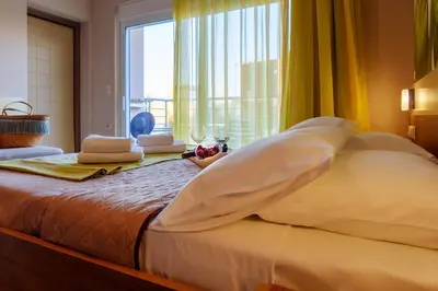 a bedroom with a large bed with a large window at Relax Hotel in Palaiochóra