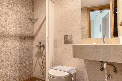 a bathroom with a toilet and a sink and a mirror at Relax Hotel in Palaiochóra