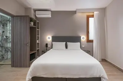 a bedroom with a large white bed and a window at Al Daliani Minaret Rooms in Chania Town