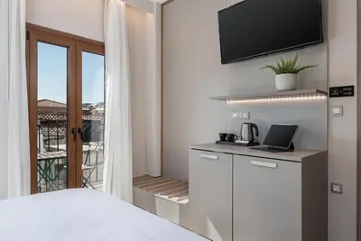 a bedroom with a bed and a view of a balcony at Al Daliani Minaret Rooms in Chania Town