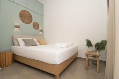 a bedroom with a bed with white sheets and a chair at Eden of grameno Luxury sea view apartment in Palaiochóra