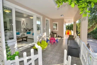 a porch with a white fence and a living room at *Haritos traditional Apt-5min from Falassarna Bch* in Kissamos