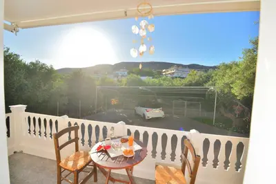 a patio with a table and chairs on a balcony at *Haritos traditional Apt-5min from Falassarna Bch* in Kissamos