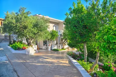a building with trees and flowers on a sidewalk at *Haritos traditional Apt-5min from Falassarna Bch* in Kissamos
