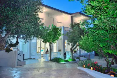 a white house with trees in front of it at *Haritos traditional Apt-5min from Falassarna Bch* in Kissamos