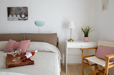a room with a bed with a tray with wine glasses at Sunset Home with sea view in Chania Town
