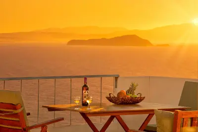 a table with a basket of fruit and a bottle of wine at Sunset Home with sea view in Chania Town