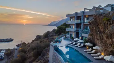 a hotel on the side of a mountain with a pool at panorama new generation in Sfakiá