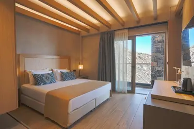 a bedroom with a large bed and a large window at panorama new generation in Sfakiá
