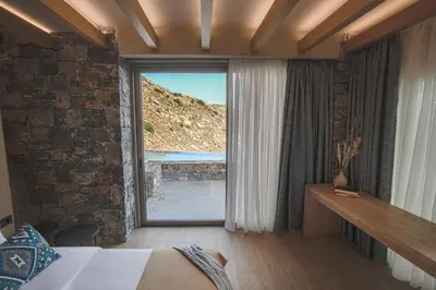 a bedroom with a bed and a large window at panorama new generation in Sfakiá