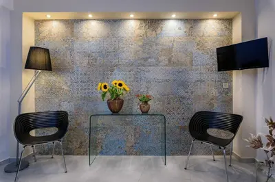 a dining room with two chairs and a table with flowers on it at Family home w. yard in Beating Heart of Old Town in Chania Town