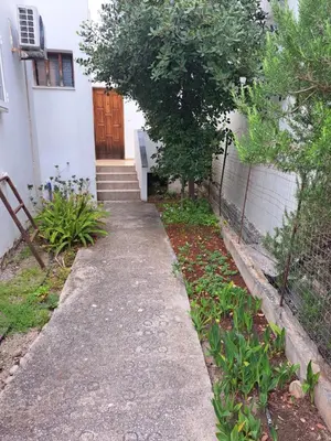 a path leading to a house with a wooden door at LITHI in Palaiochóra