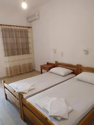 two beds in a room with a window at LITHI in Palaiochóra