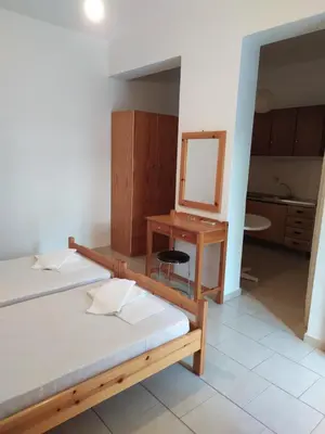a room with two beds and a desk and a mirror at LITHI in Palaiochóra