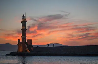 a lighthouse in the middle of the water at sunset at Valentina's Luxury House in Chania Town