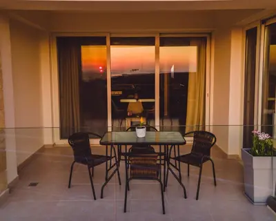 a table and chairs in a balcony with a view of the sunset at Cretan fleur apartments in Elafonisi