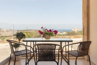 a table and chairs on a balcony with a view at Cretan fleur apartments in Elafonisi