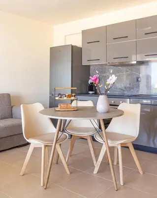 a dining room table and chairs with a vase of flowers at Cretan fleur apartments in Elafonisi