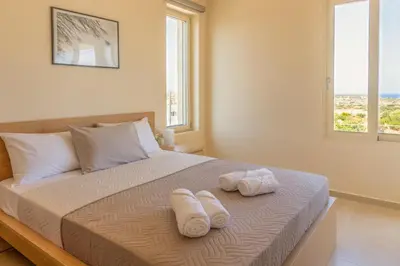 a bedroom with two towels on a bed with a window at Cretan fleur apartments in Elafonisi