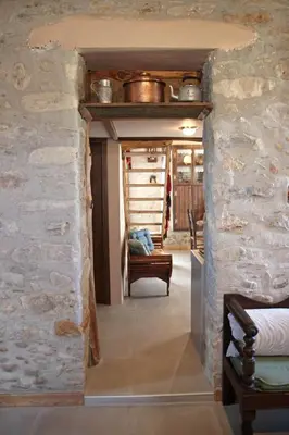 a hallway in a house with a stone wall at Laini Guest Houses in Koulkouthianá