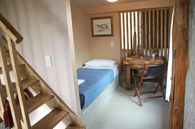 a small room with a bed and a desk and a staircase at Laini Guest Houses in Koulkouthianá