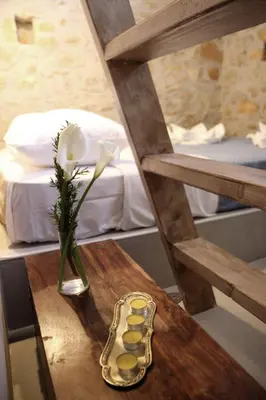 a table with a vase of flowers and pills on a bed at Laini Guest Houses in Koulkouthianá