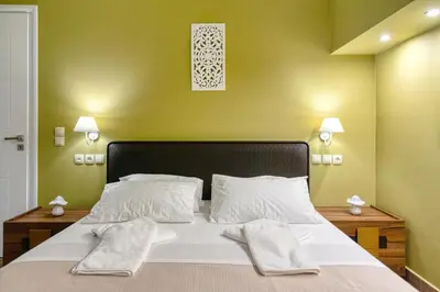 a bedroom with a large white bed with green walls at Villa Hope in Chania in Mourniaí