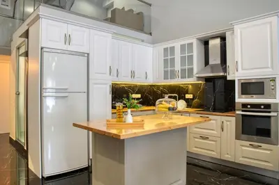 a kitchen with white cabinets and a white refrigerator at Villa Hope in Chania in Mourniaí