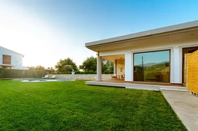 a house with a large yard with green grass at Chania Oasis with heated pool in Chania Town