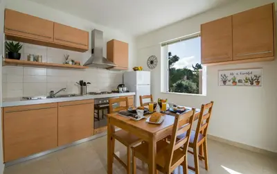 a kitchen with a wooden table and wooden cabinets at Artdeco Luxury Suites in Korakiaí