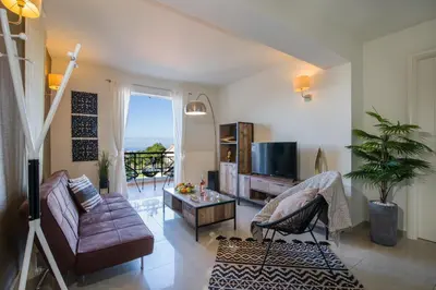 a living room with a couch and a tv at Artdeco Luxury Suites in Korakiaí